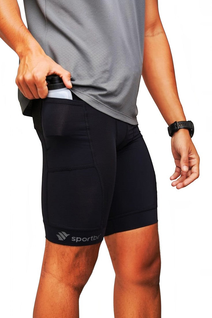 Bermuda de compressão preta SPORTBR com bolsos laterais para corrida, vestida por um atleta guardando uma garrafa.