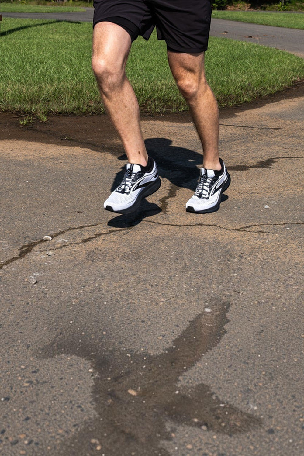 Corredor usando tênis com cadarço elástico preto refletivo SPORTBR em uma pista de corrida ao ar livre