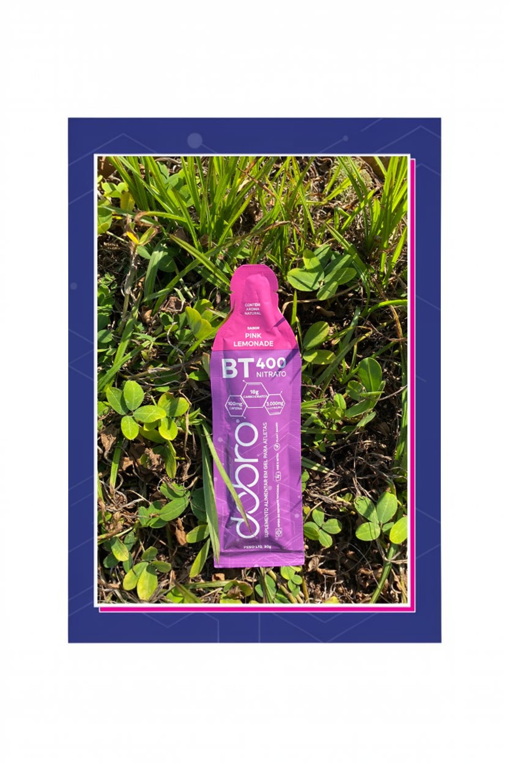 Sachê de gel de carboidrato SPORTBR DOBRO sabor Pink Lemonade com nitrato, cafeína e L-Citrulina sobre gramado.