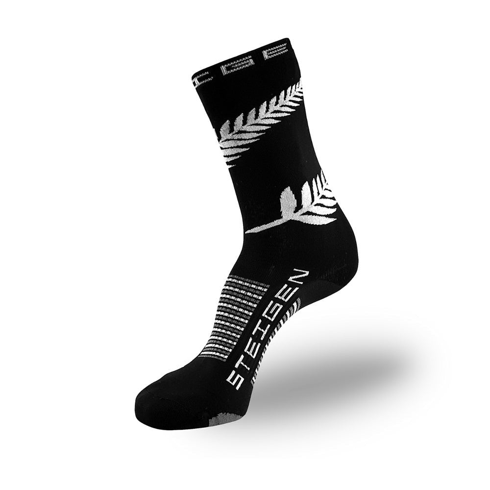 Meia cano alto preta Steigen Nova Zelândia com estampa de samambaia branca e logo da marca. Feita em nylon e lycra.