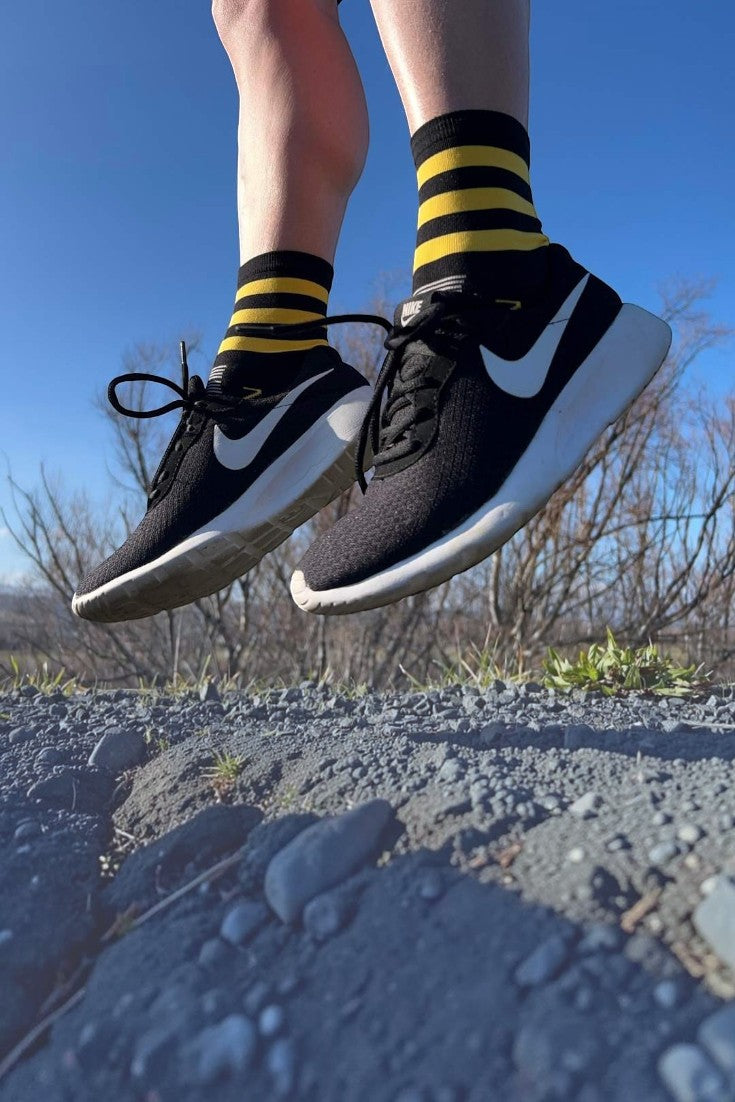 Meia esportiva SPORTBR Steigen cano médio Bumble Bee com listras amarelas e pretas em corredor saltando