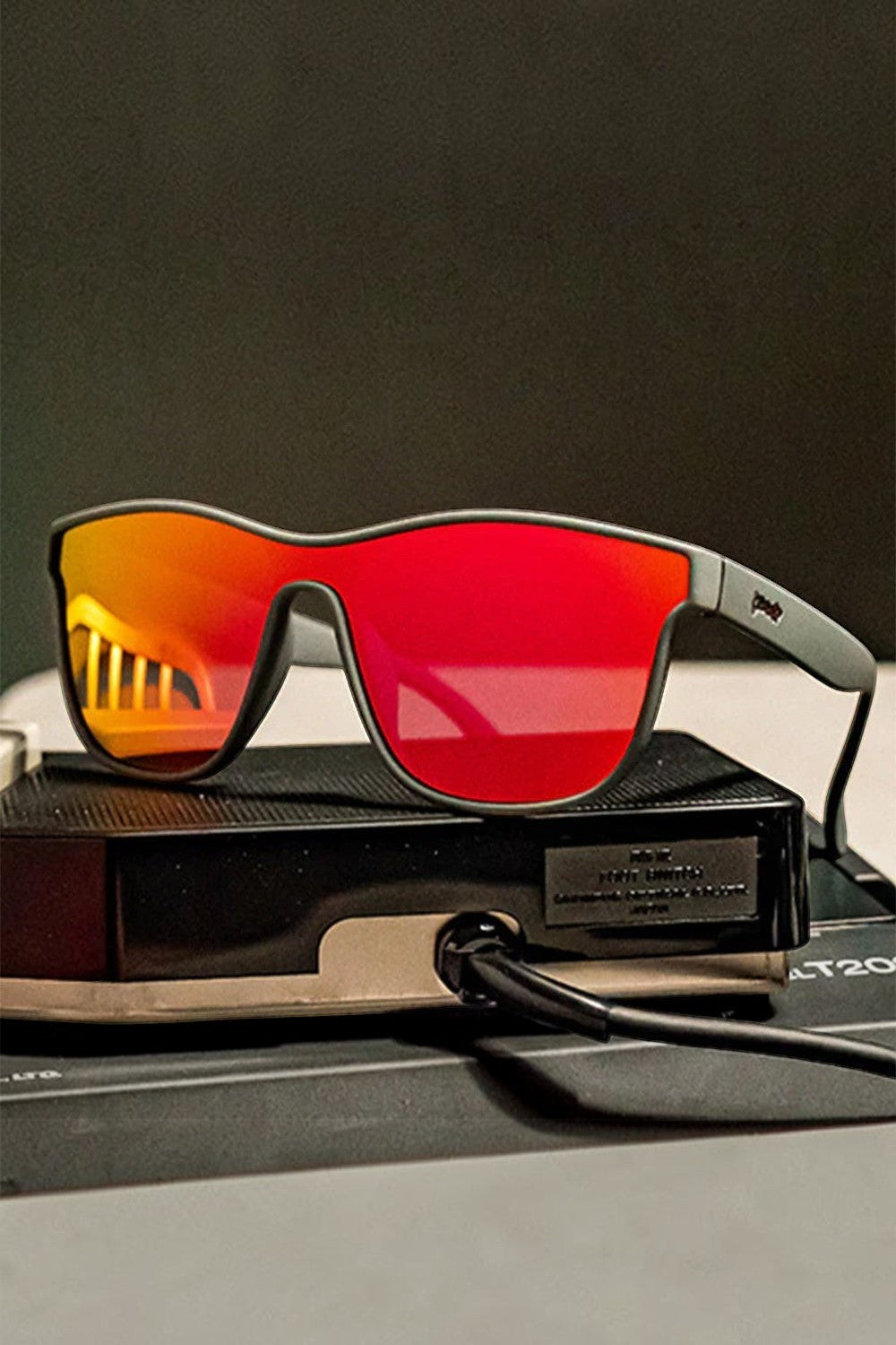 Óculos de sol SPORTBR Goodr Voight-Kampff Vision com armação cinza e lentes espelhadas laranja polarizadas.