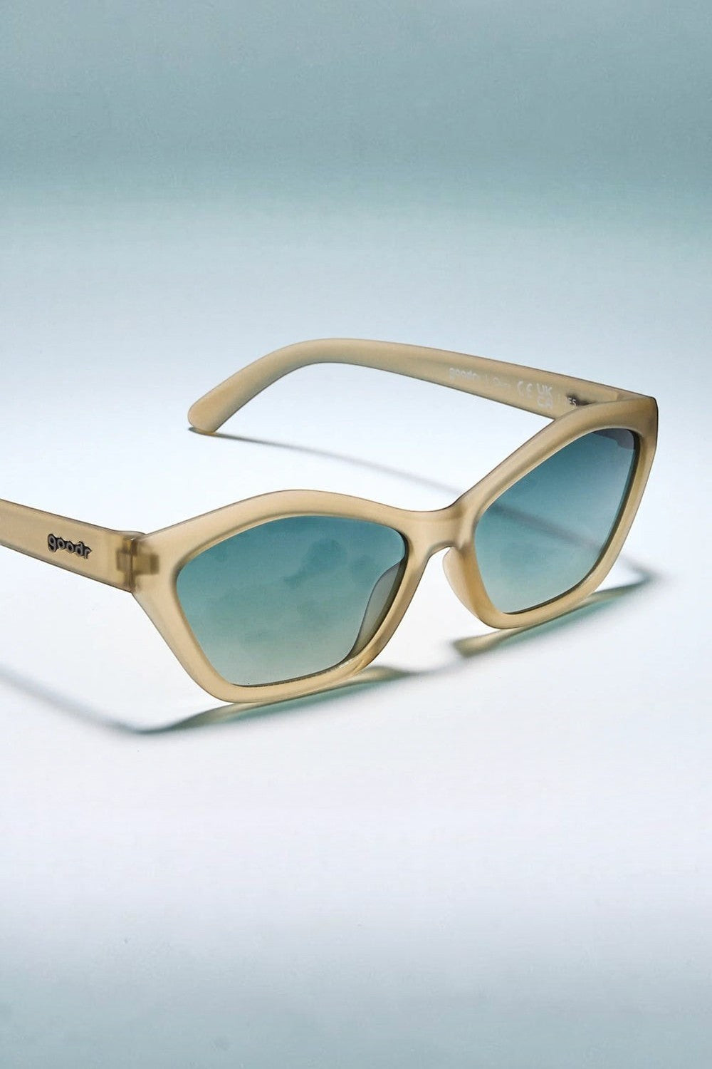 Óculos de sol SPORTBR Goodr Dulce De Leche Luxe com armação cinza translúcida e lentes polarizadas verde-escuro degradê.