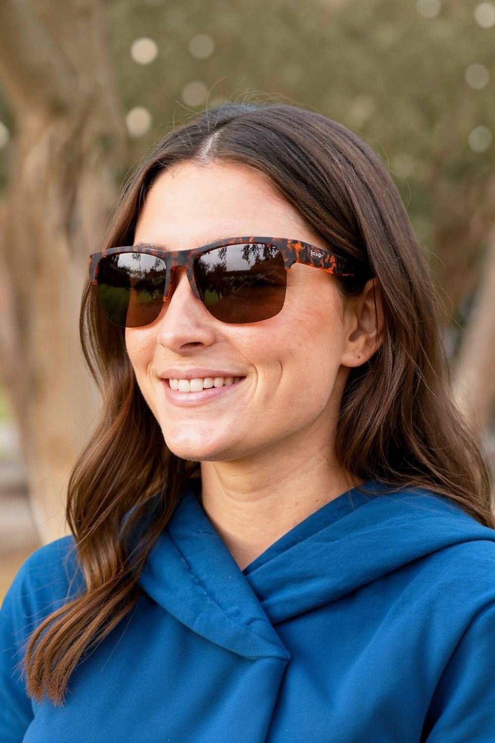 Mulher usando óculos de sol Goodr Country Club Crasher com armação marrom tartaruga e lentes polarizadas da SPORTBR