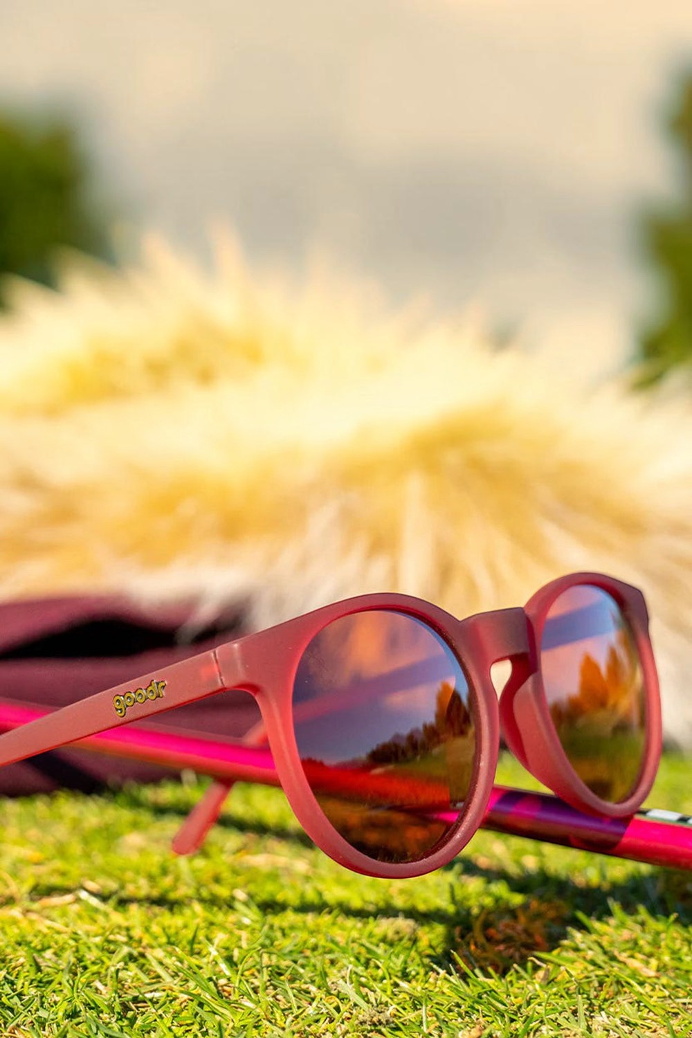 Óculos de sol SPORTBR Goodr Circle G na cor bordô com lentes marrons polarizadas em ambiente externo de corrida.