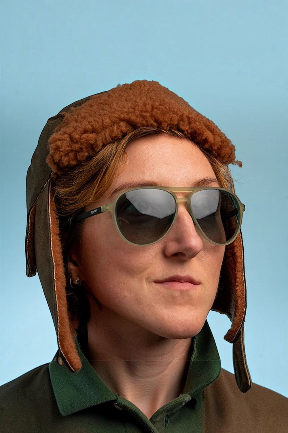 Mulher usando óculos de sol Goodr Buzzed on the Tower verdes com lentes polarizadas, vendidos pela SPORTBR.