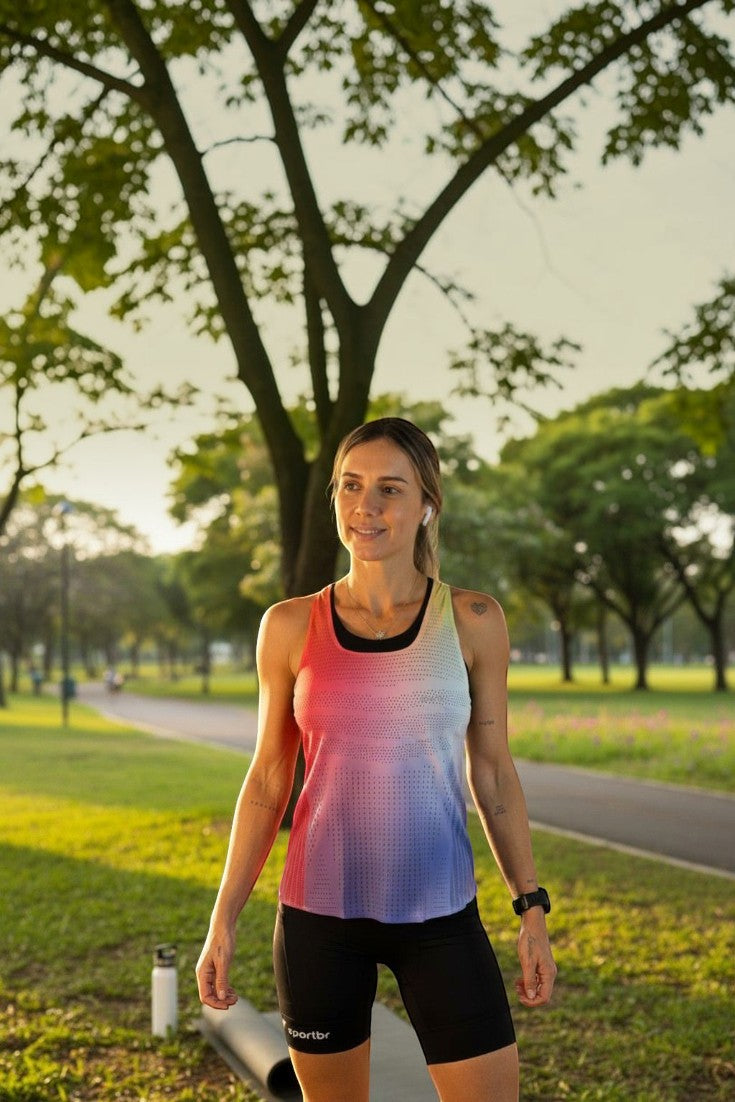 Mulher usando regata de corrida SPORTBR AirMesh colorida com degradê em parque durante o dia.