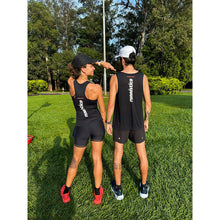Mulher e homem utilizando a regata sportbr preta com estampa marca Julia Sette e frase Runnístico nas costas.