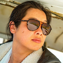 Óculos de sol SPORTBR Amelia Earhart Ghosted Me marrom com armação tartaruga e lentes polarizadas marrons.