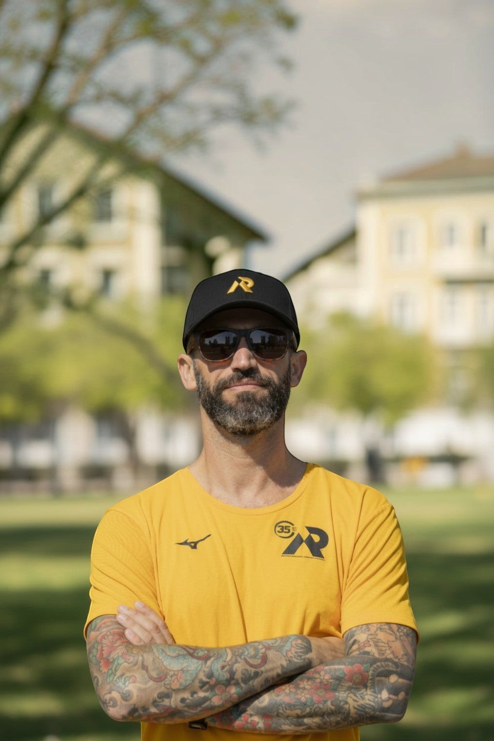 Homem usando boné preto SPORTBR com logo dourado bordado, ao ar livre em um dia ensolarado.