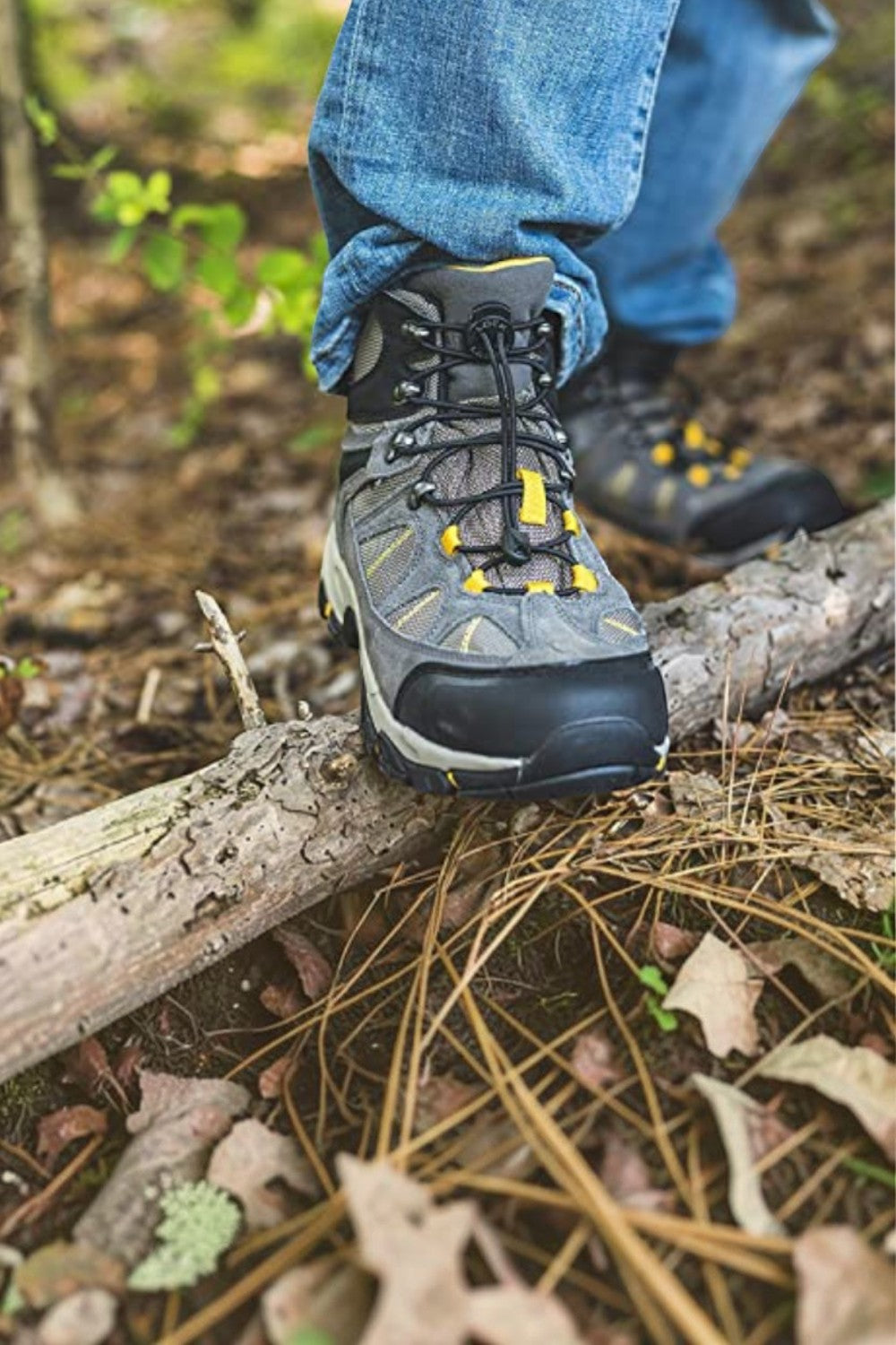 Cadarço elástico preto SPORTBR Lock Laces instalado em bota de trilha cinza com detalhes amarelos em ambiente externo