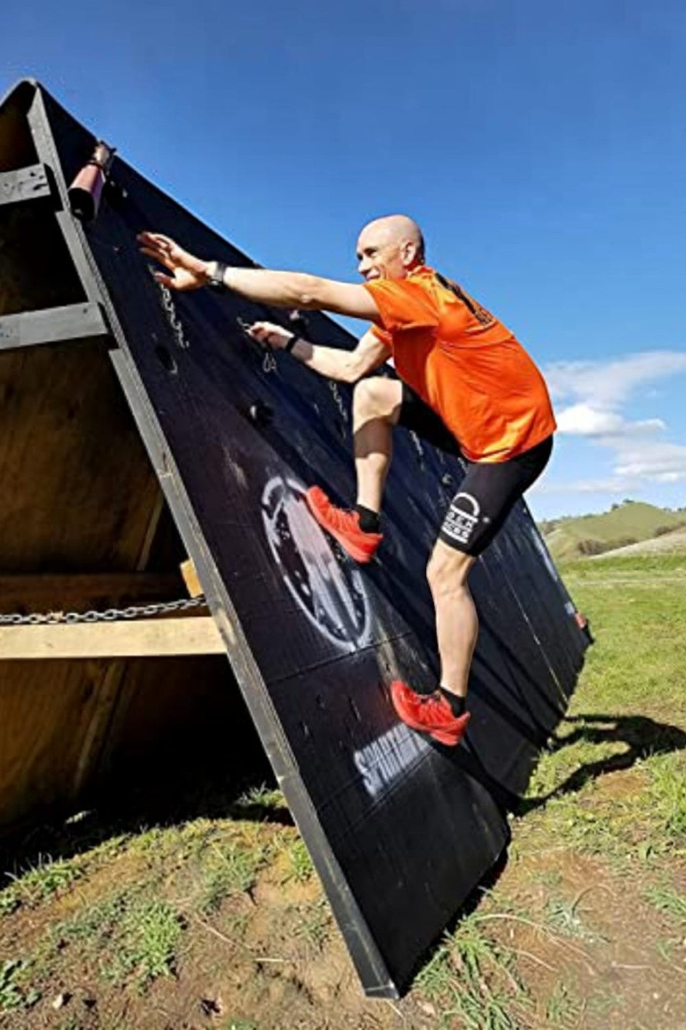 Atleta usando cadarço elástico SPORTBR Lock Laces em tênis vermelho durante prova de obstáculos ao ar livre