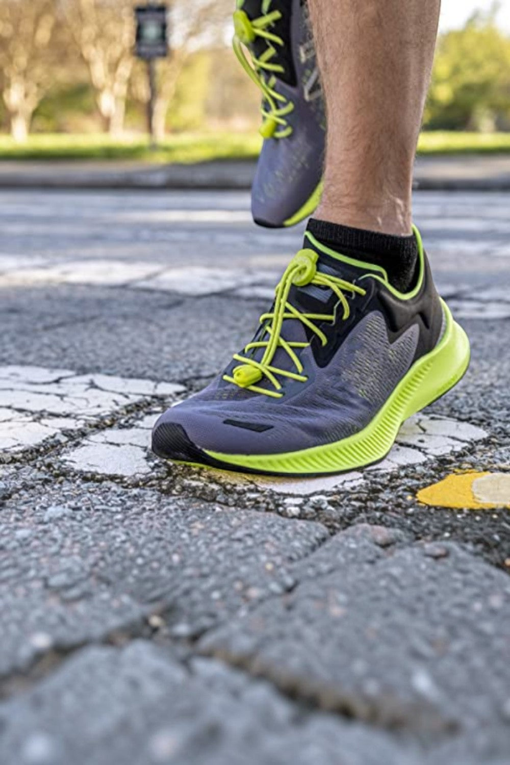 Cadarço elástico Lock Laces SPORTBR na cor maçã verde instalado em tênis de corrida cinza em uso ao ar livre
