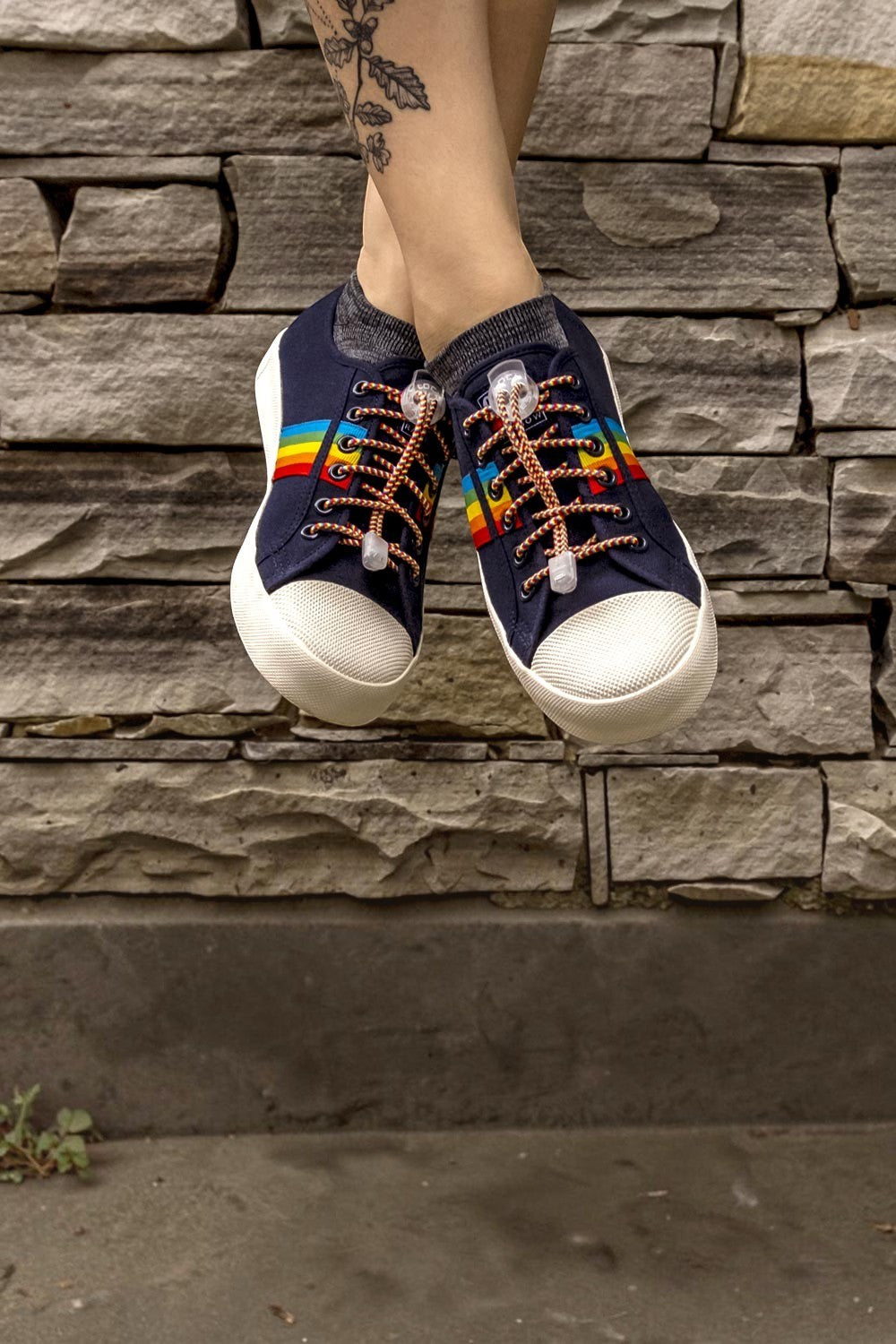 Cadarço elástico SPORTBR Lock Laces Rainbow em tênis azul, com sistema de ajuste rápido e design colorido.