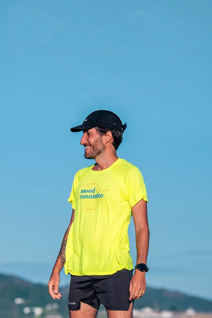 Homem vestindo camiseta esportiva SPORTBR amarela neon de poliamida com estampa Mood em ambiente externo ensolarado