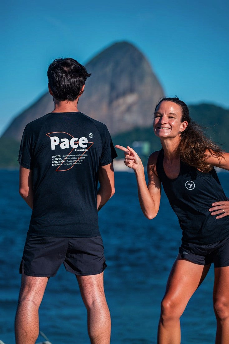Homem vestindo camiseta preta Julia Sette Pace da SPORTBR com estampa nas costas, ao lado de mulher, ao ar livre.