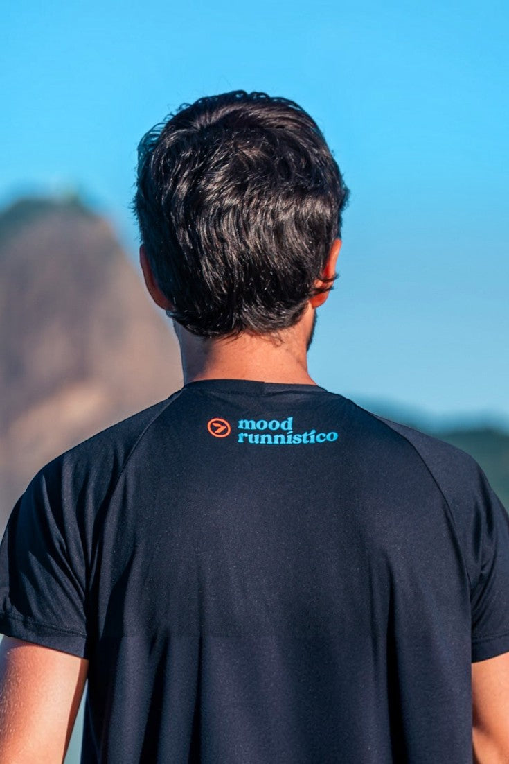 Homem vestindo camiseta esportiva preta de poliamida SPORTBR com estampa Mood Runístico nas costas ao ar livre