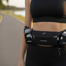 Cinto de hidratação preto Fitletic com duas garrafas laterais, bolso frontal e porta gel, usado por modelo em paisagem de corrida.