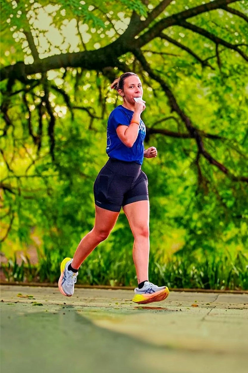 Atleta SPORTBR correndo em parque ao ar livre enquanto consome sachê de Hidro Gel Tech Dobro neutro