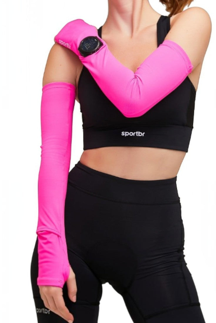 Manguito esportivo rosa SPORTBR com abertura para relógio de corrida, usado por corredora com top e bermuda pretos.