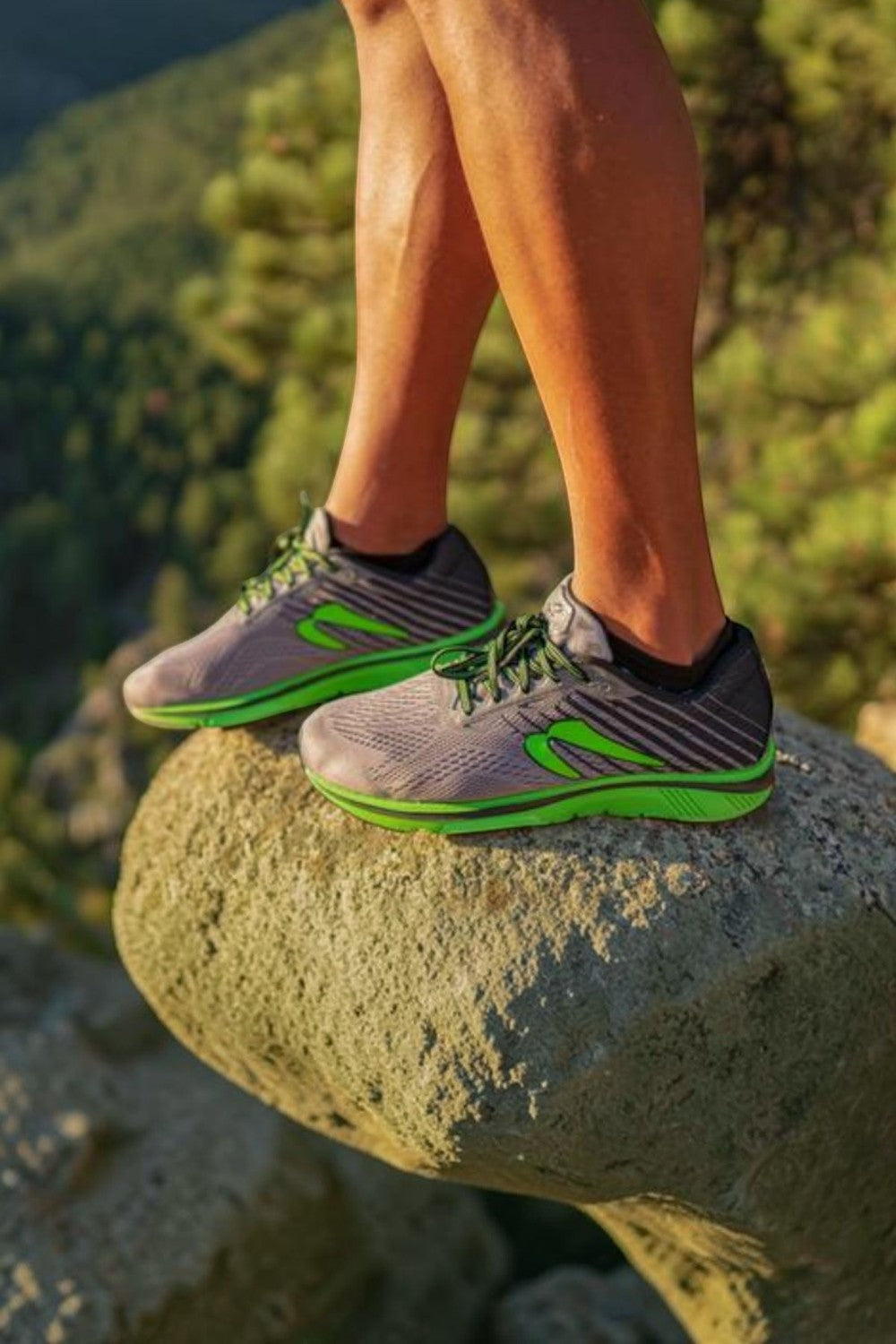 Meia de compressão preta SPORTBR Swiftwick Aspire Zero em corredor com tênis esportivo em ambiente de trilha