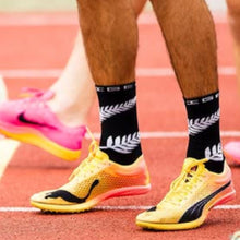 Meia Steigen cano alto preta com estampa de samambaia branca, ideal para corrida e esportes.
