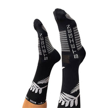 Meia Steigen cano alto preta com estampa de samambaia branca e logo da marca. Feita em nylon e lycra.