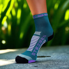 Meia cano médio Steigen Emerald em tecido leve com detalhes em roxo e branco, ideal para corrida.