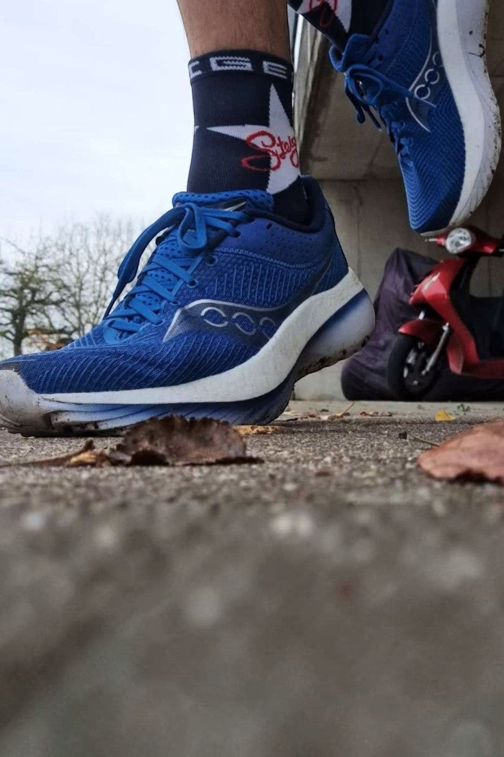 Meia Steigen cano médio modelo Rock Star azul e preta em uso com tênis de corrida azul da SPORTBR