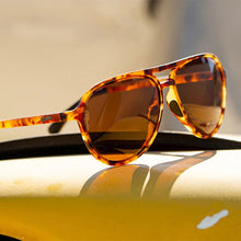 Óculos de sol Goodr Amelia Earhart Ghosted Me marrom com armação tartaruga e lentes polarizadas marrons.