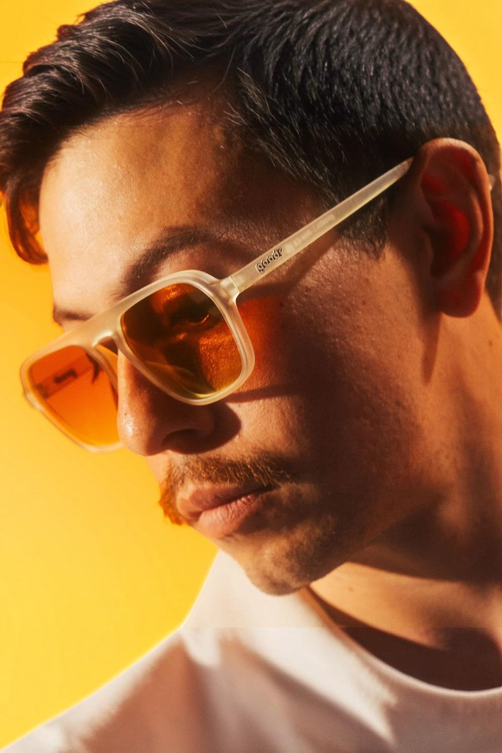 Homem usando óculos de sol SPORTBR Goodr Impromptu Disco Nap com armação cinza e lentes laranja polarizadas