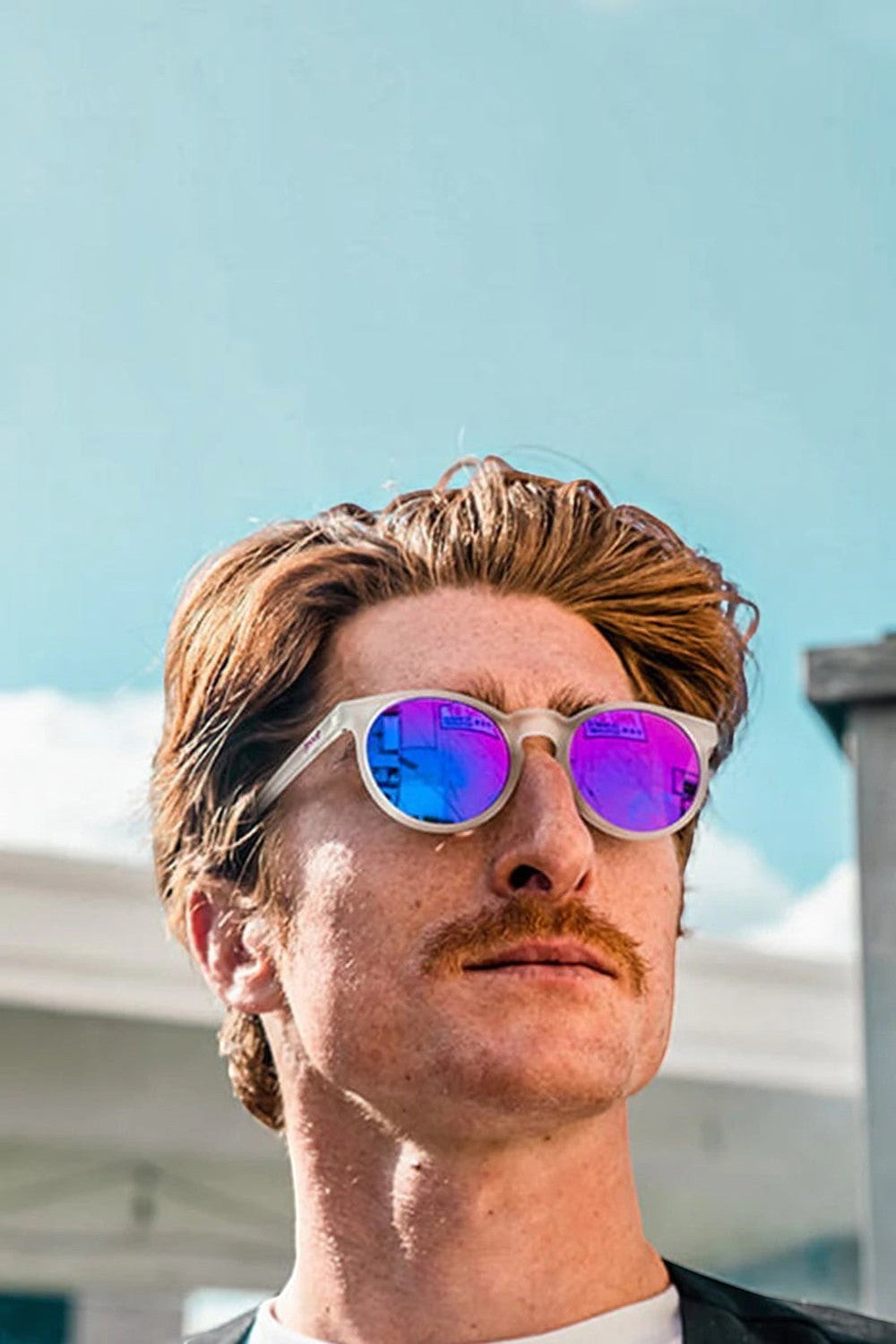 Homem usando óculos de sol SPORTBR Goodr Circle G com armação branca e lentes espelhadas roxas para corrida