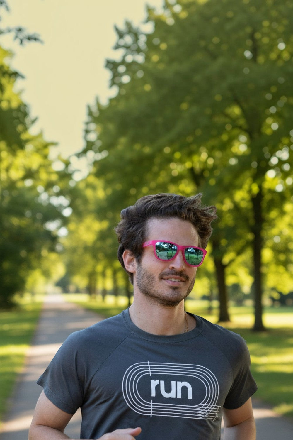 Homem correndo em parque usando óculos de sol SPORTBR Goodr rosa com lentes espelhadas azuis polarizadas