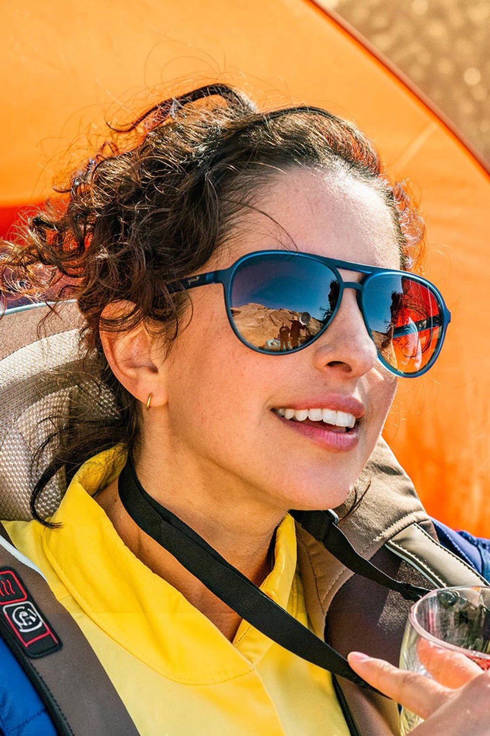 Mulher usando óculos de sol Goodr Frequent SkyMall Shoppers com armação azul e lentes marrons polarizadas da SPORTBR
