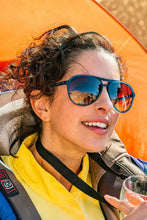Mulher usando óculos de sol Goodr Frequent SkyMall Shoppers com armação azul e lentes marrons polarizadas da SPORTBR