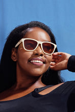 Modelo usando óculos de sol SPORTBR Goodr Toasted Marshmallow Magic com armação bege e lentes degradê fumê.