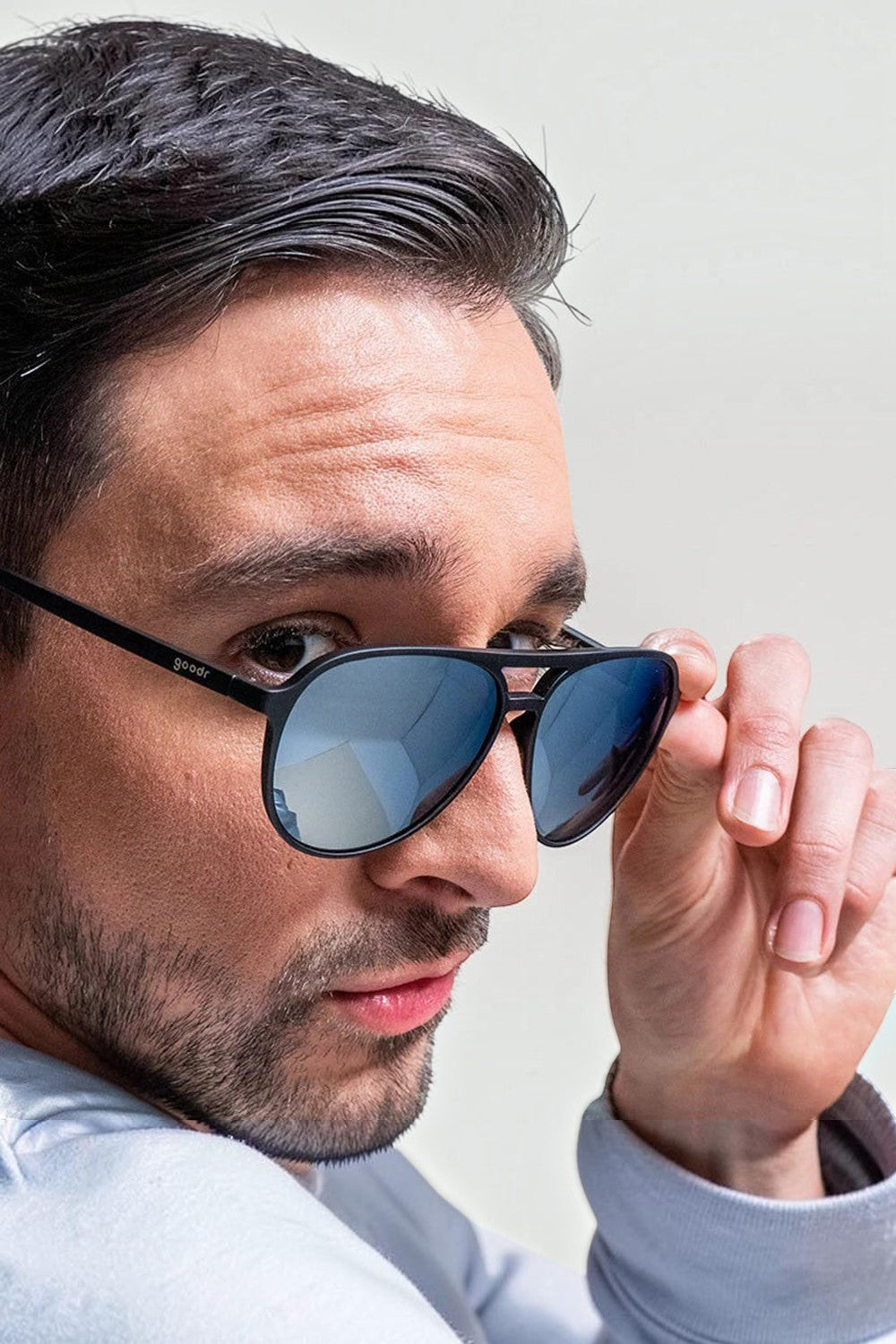 Homem usando óculos de sol SPORTBR Goodr Add the Chrome Package com armação preta e lentes espelhadas cinzas