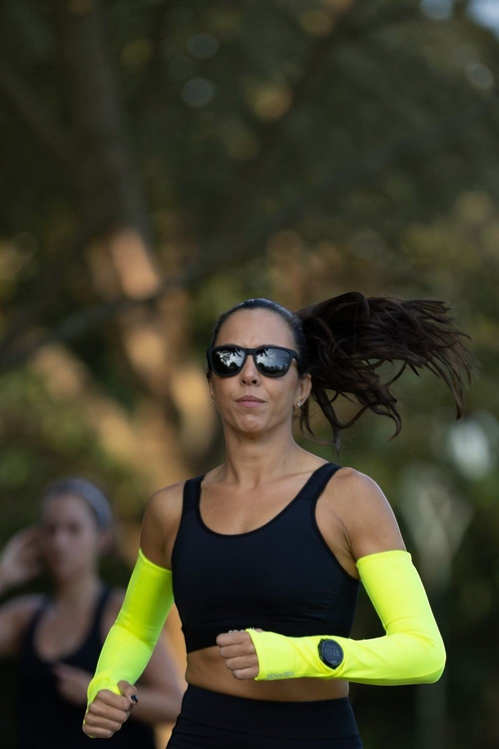Mulher correndo ao ar livre usando óculos de sol pretos Goodr A Unicorn's Calamity da SPORTBR com lentes polarizadas