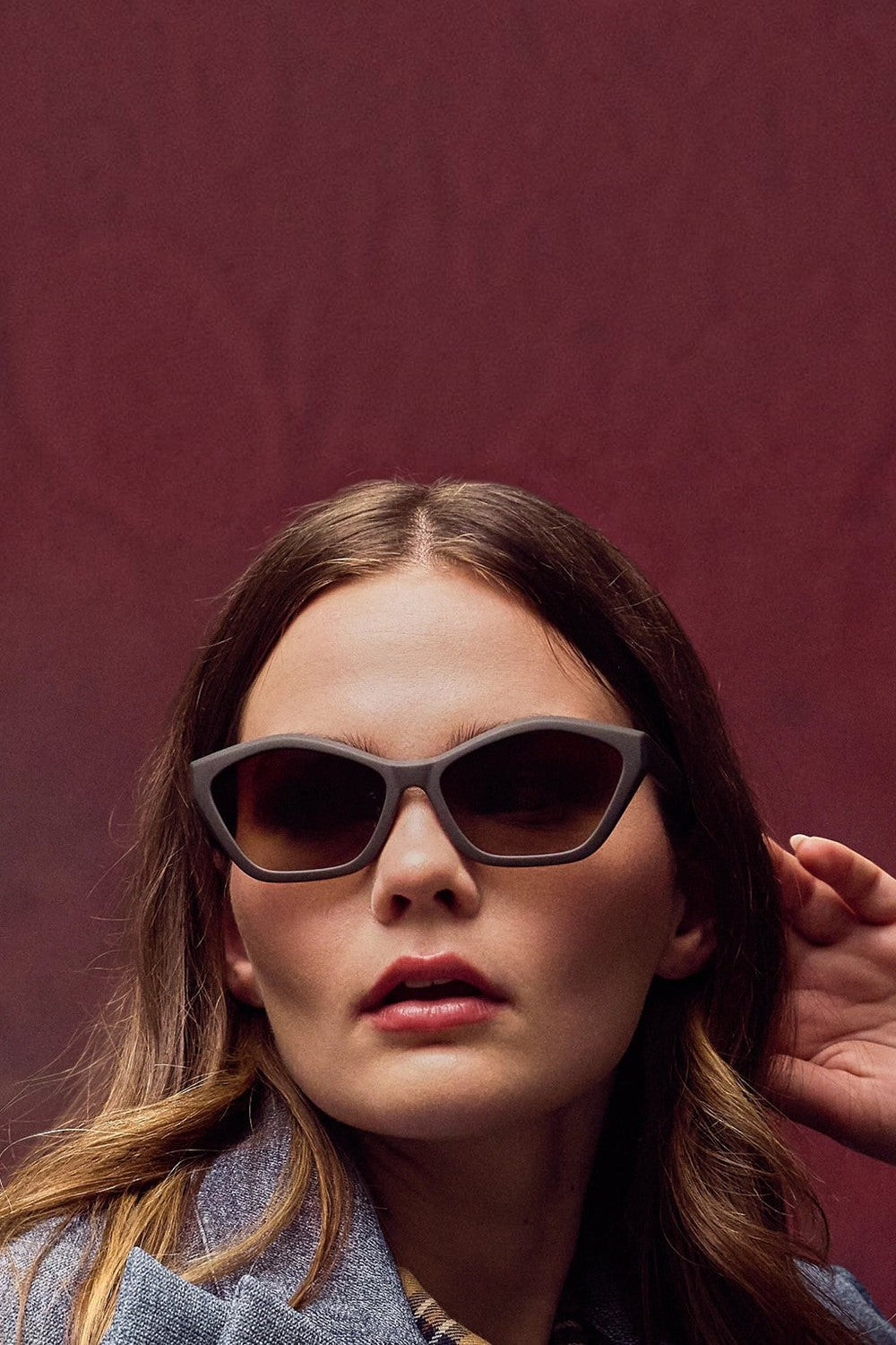 Mulher usando óculos de sol SPORTBR Goodr Walnut Wonderland com armação e lentes marrons em formato Deco G.