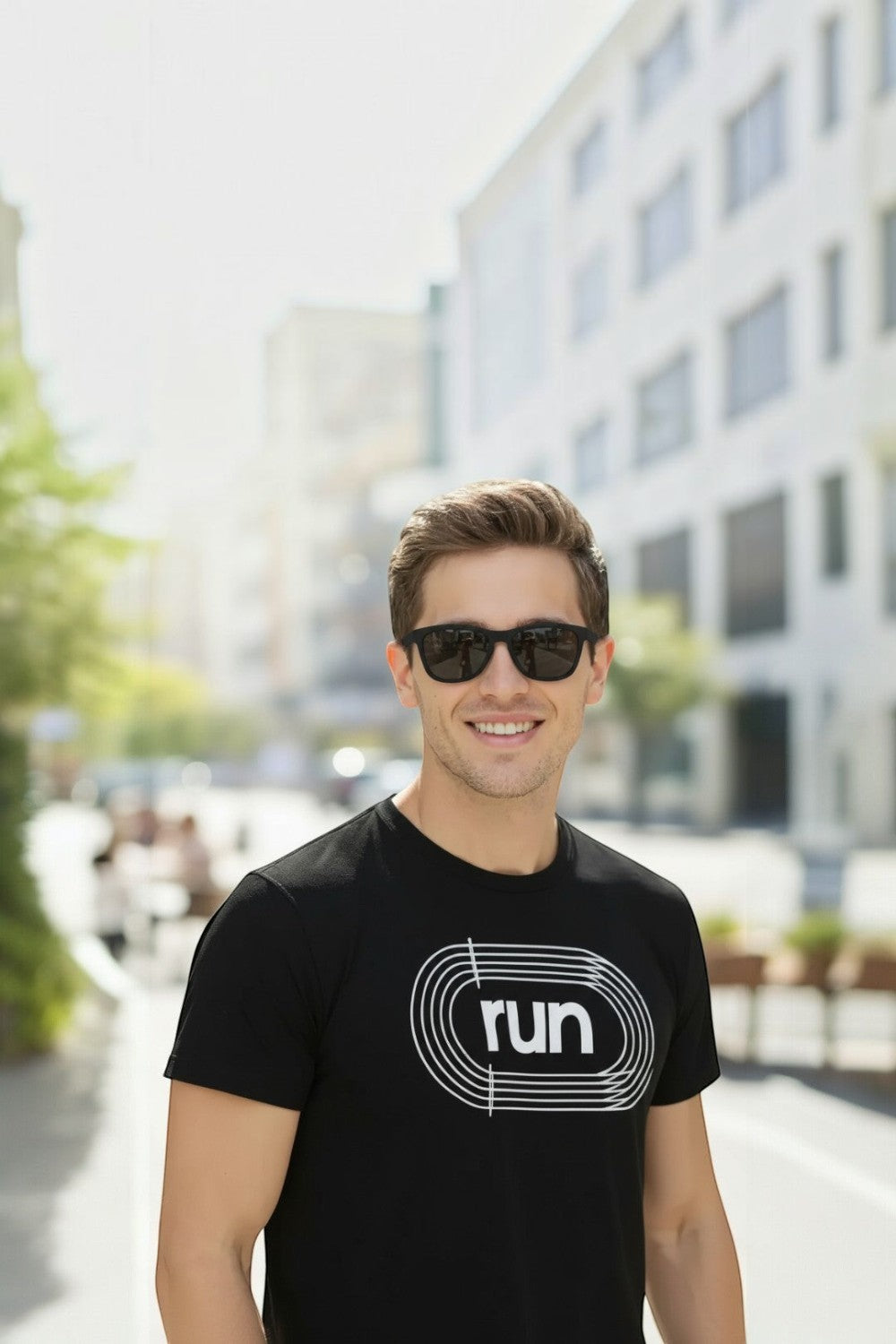 Homem sorridente usando óculos de sol pretos Goodr A Unicorn's Calamity da SPORTBR em ambiente urbano ao ar livre