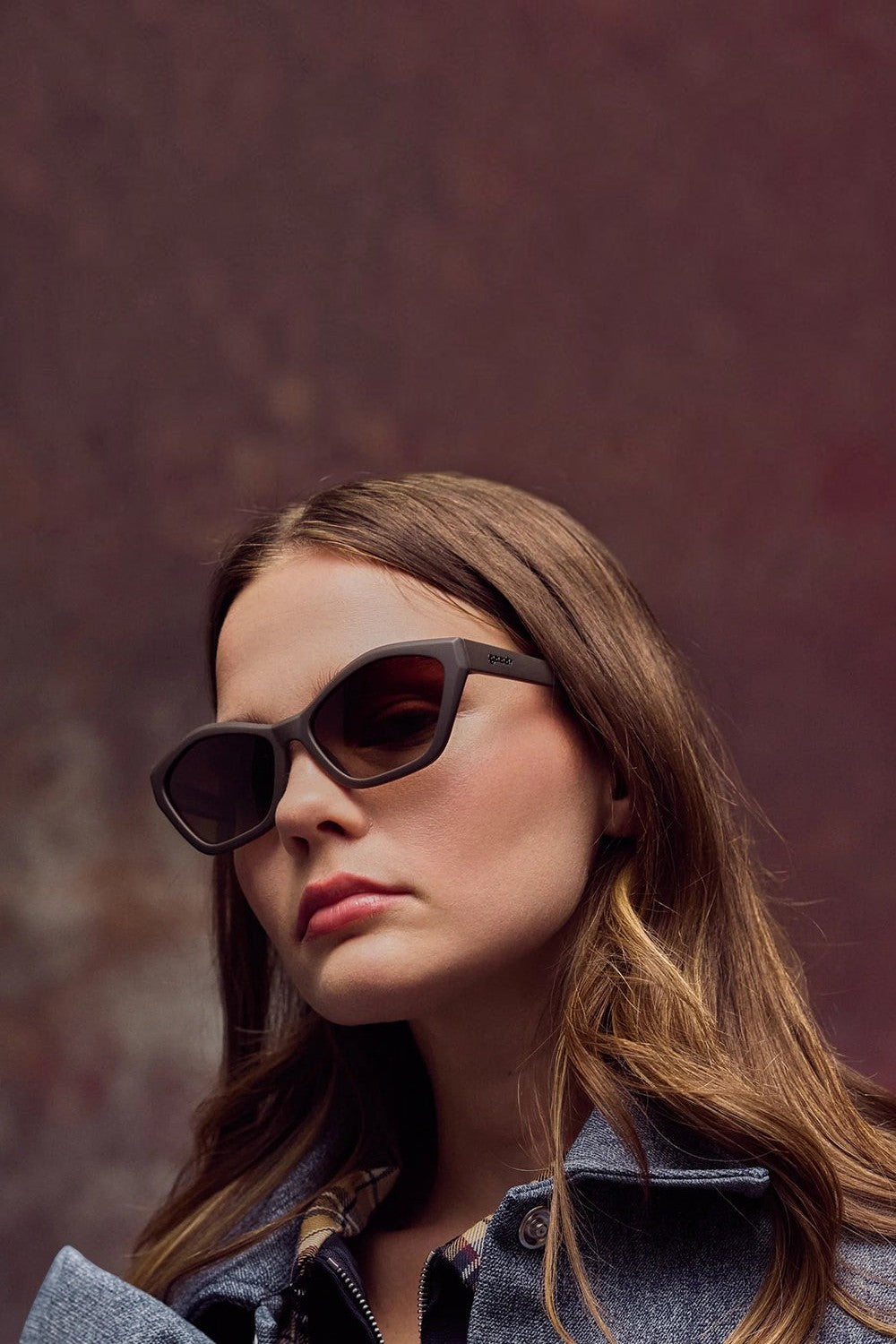 Mulher usando óculos de sol SPORTBR Goodr Walnut Wonderland marrons com armação de propionato e lentes polarizadas.