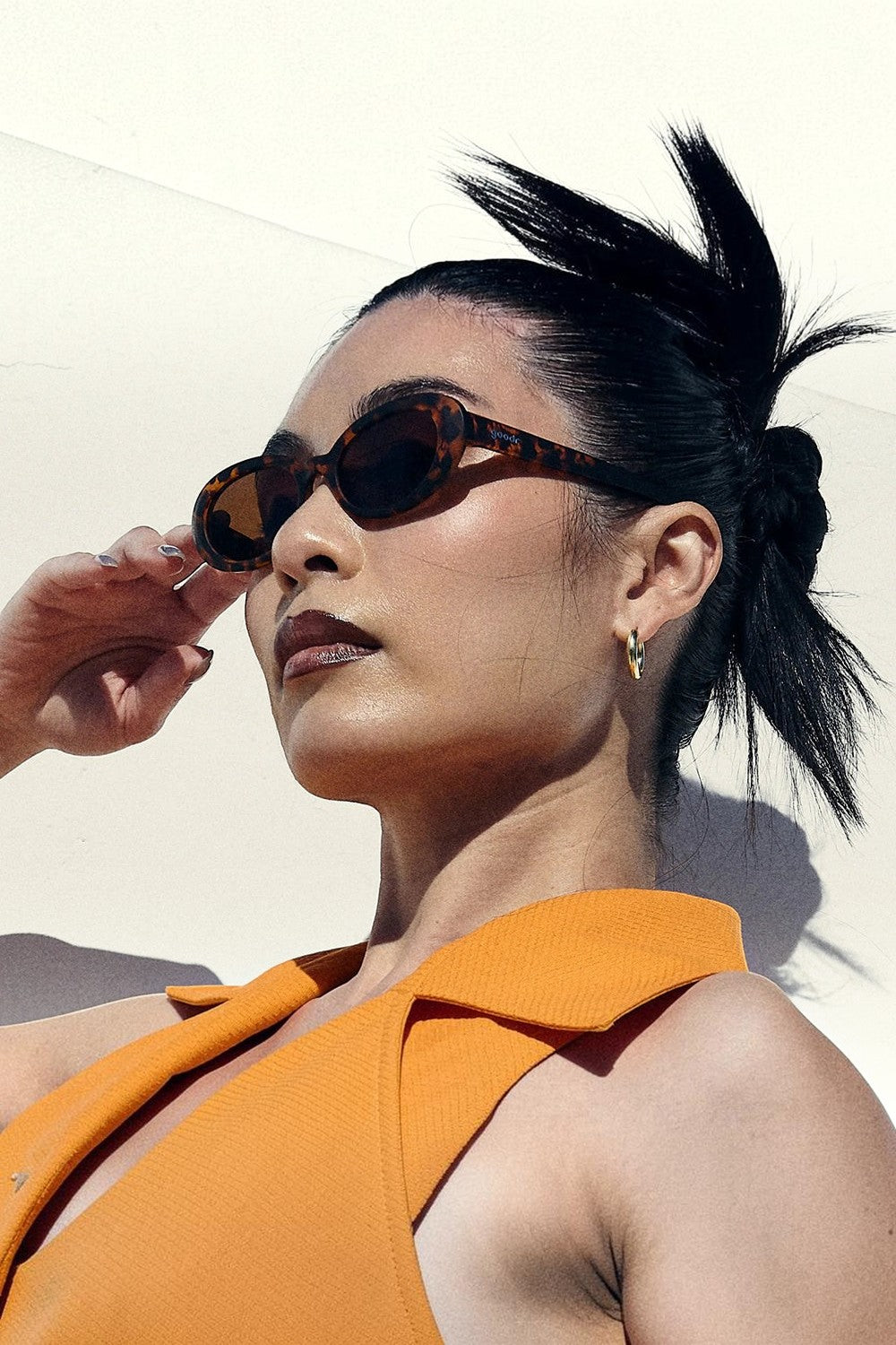 Modelo usando óculos de sol SPORTBR Goodr Karaoke Machine Solo com armação tartaruga e lentes marrons polarizadas