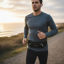 Pochete preta Fitletic Ultimate II com porta géis e bolso lateral, usada por homem correndo ao ar livre.