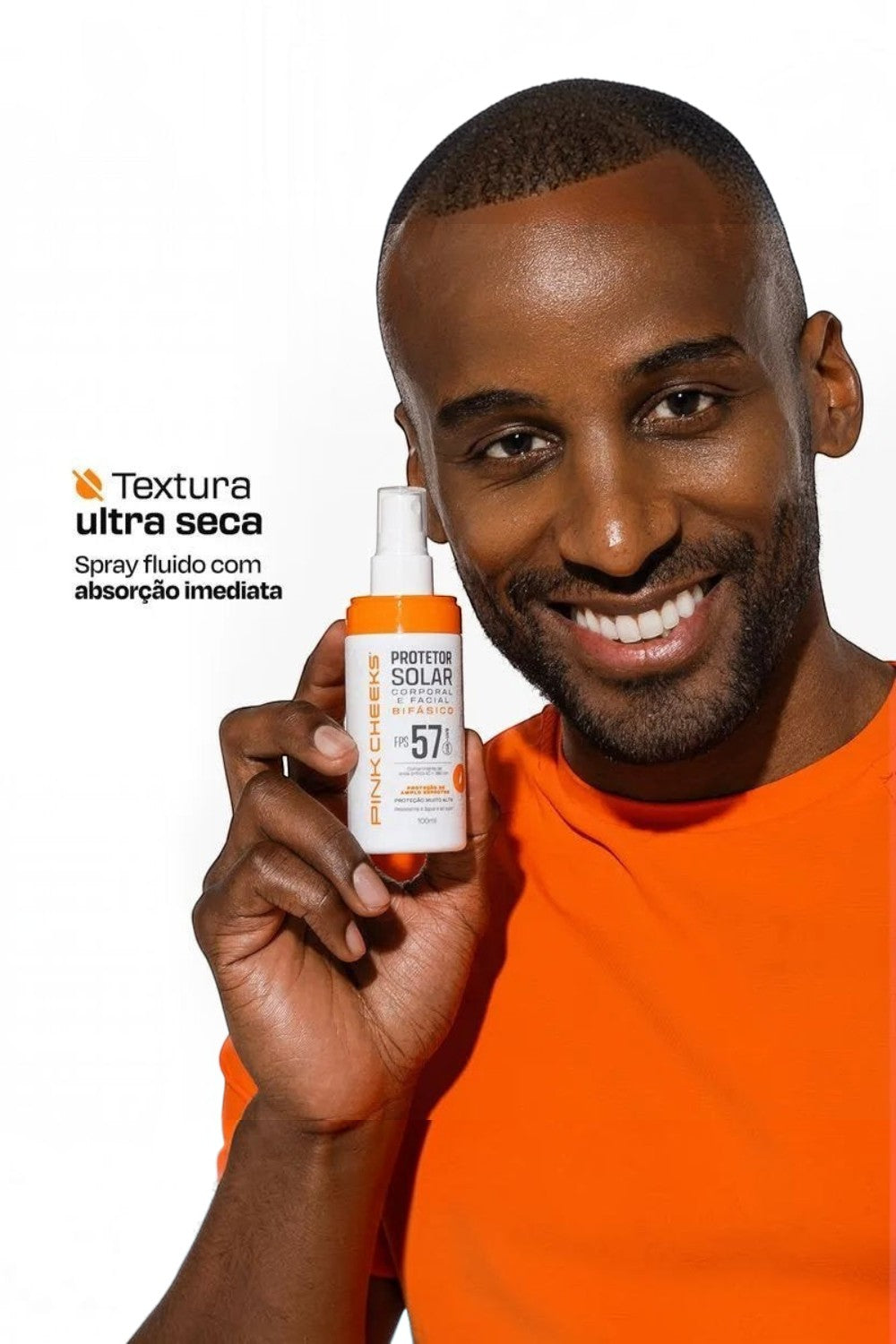 Homem sorridente segurando protetor solar bifásico SPORTBR Pink Cheeks FPS 57 em spray com textura ultra seca.