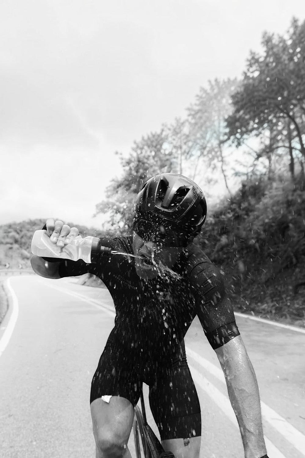 Ciclista SPORTBR usando sachê de energia Z2 Power Powder para se refrescar durante treino intenso na estrada