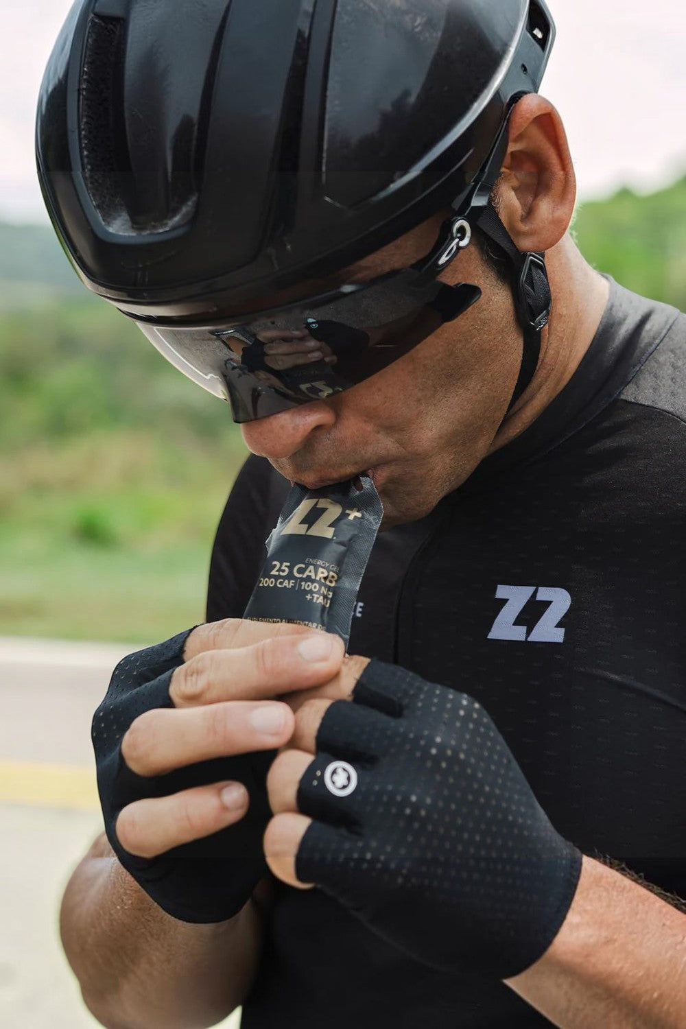 Ciclista SPORTBR consumindo sachê de gel de carboidrato Z2+ sabor Double Expresso durante treino ao ar livre