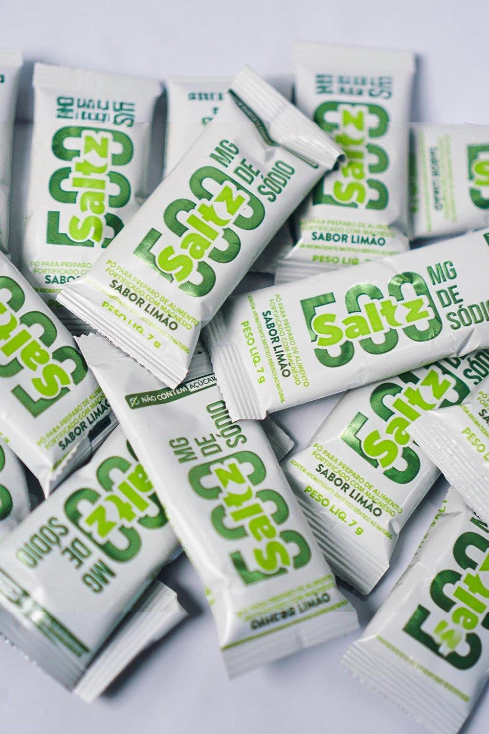 Caixa com 10 sachês de repositor eletrolítico SPORTBR Saltz 500 Z2 sabor limão, embalagens brancas com detalhes verdes.