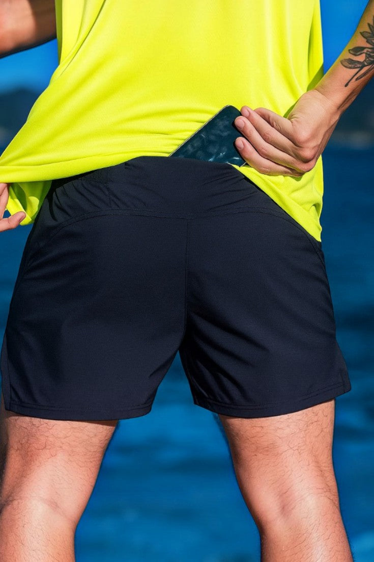 Shorts de corrida masculino preto SPORTBR com bolso traseiro no cós, visto de costas em um corredor ao ar livre.