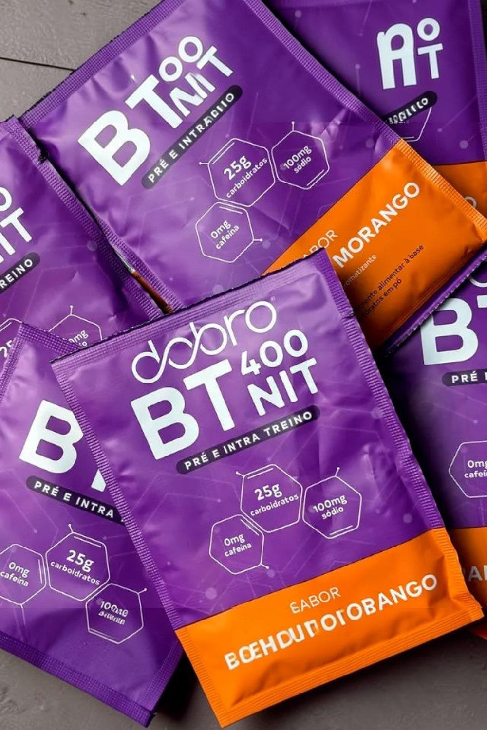 Caixa com 10 sachês de suplemento pré e intra treino SPORTBR BT Nitrato sabor laranja e morango em embalagem roxa