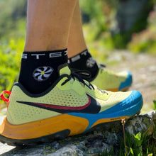 Meia Steigen cano baixo preta com logo de catavento, feita de nylon e lycra para corrida e esportes.